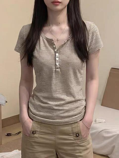 Henry indossa una camicia a righe a maniche corte